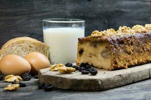 brood pudding, gemaakt met melk, eieren, muf brood en droog fruit Aan rustiek houten achtergrond foto