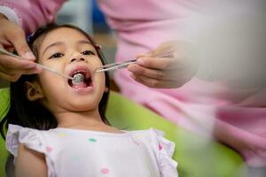 weinig Aziatisch meisjes tanden zijn gezond in de tandheelkundig kantoor. tandheelkundig zorg, tandarts zorg. foto