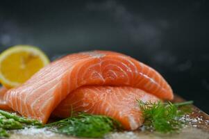 vers rauw Zalm vis Aan ijs voor Koken voedsel zeevruchten Zalm vis, Zalm filet met citroen asperges kruid en specerijen foto