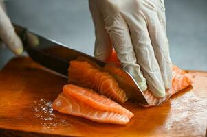 vers rauw Zalm vis filet met keuken mes voor Koken voedsel zeevruchten Zalm vis, Zalm filet Aan houten snijdend bord foto