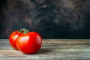 tomaten Aan een houten tafel met een donker achtergrond foto