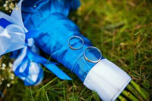 bruiloft ringen en bruids boeket aan het liegen Aan groen gras foto