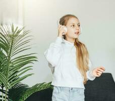 schattig weinig meisje luisteren naar muziek- in hoofdtelefoons foto