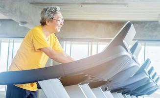 Aziatische oudere man trainen in de sportschool foto