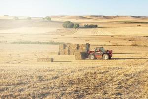 landbouwmachines die het land op een zonnige dag bewerken foto