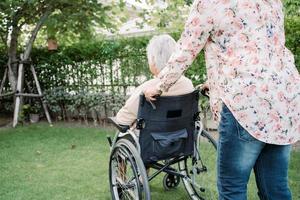 help aziatische senior of oudere oude dame vrouw op elektrische rolstoel en het dragen van een gezichtsmasker ter bescherming van de veiligheid infectie covid 19 coronavirus in park foto