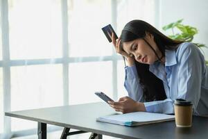 ongelukkig Aziatisch jong vrouw zittend Bij huis gebruik makend van mobiel telefoon hebben probleem boodschappen doen online met een credit kaart. gevoel angstig en verward door de fouten van internet bankieren. foto