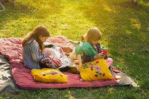 twee kleine meisjes picknicken in de achtertuin foto