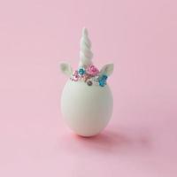 enkel wit ei met creatieve minimale Pasen-achtergrond van de eenhoorndecoratie