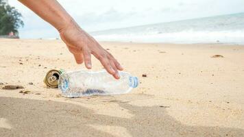 hand- plukken omhoog plastic fles schoonmaak Aan de strand. opslaan de wereld concept. omgeving, ecologie zorg, hernieuwbaar begrip, natuur behoud toerisme foto
