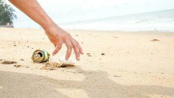 hand- plukken omhoog plastic fles schoonmaak Aan de strand. opslaan de wereld concept. omgeving, ecologie zorg, hernieuwbaar begrip, natuur behoud toerisme foto