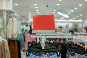 selectief focus naar blanco rood bord voor vrouwen en Mannen kleding korting sjabloon in winkelcentrum. zacht focus foto