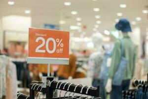 selectief focus naar rood korting bord met 20 procent schrijven. voor korting Sjablonen voor vrouwen en Mannen kleding Bij de winkelcentrum. zacht focus foto