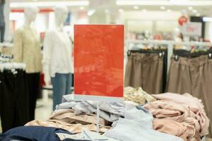 selectief focus naar blanco rood bord voor vrouwen en Mannen kleding korting sjabloon in winkelcentrum. zacht focus foto