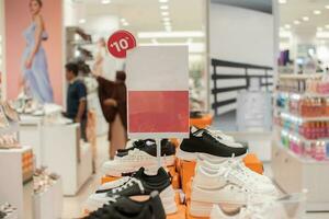 selectief focus naar blanco rood bord voor vrouwen en Mannen kleding korting sjabloon in winkelcentrum. zacht focus foto