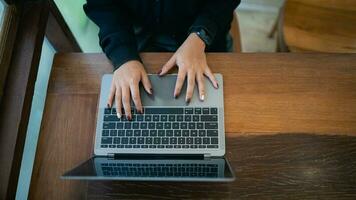 top visie handen van bedrijf freelance ondernemer vrouw met wit koptelefoon werken typen toetsenbord Aan laptop en Aan houten tafel Bij de cafe koffie winkel. bedrijf technologie concept. foto