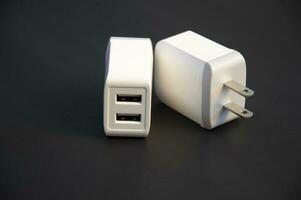 USB oplader, wit, 2-poorts type, geplaatst Aan een zwart achtergrond foto