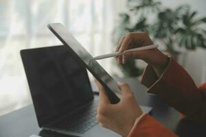 Aziatisch bedrijf vrouw gebruik makend van rekenmachine en laptop voor aan het doen wiskunde financiën Aan een kantoor bureau, belasting, rapport, boekhouding, statistieken, en analytisch Onderzoek concept foto