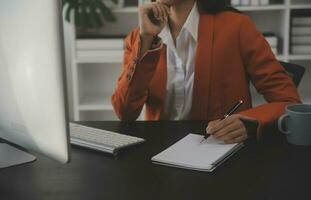 portret van jonge aziatische vrouw hand freelancer werkt haar baan op computer tablet in moderne kantoren. doen van boekhoudkundige analyse rapport vastgoedinvesteringsgegevens, financiële en fiscale systemen concept. foto