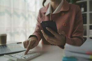 portret van jonge aziatische vrouw hand freelancer werkt haar baan op computer tablet in moderne kantoren. doen van boekhoudkundige analyse rapport vastgoedinvesteringsgegevens, financiële en fiscale systemen concept. foto