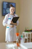 een jong glimlachen dokter gekleed in een wit professioneel uniform foto