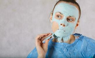 jong dame heeft een gezicht masker zittend in cosmetologisch fauteuil foto