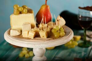 kaas plakjes, Peer, en druiven Aan een houten stellage. foto