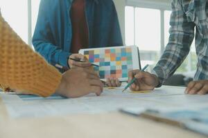 dichtbij omhoog ux ontwikkelaar en ui ontwerper brainstorming over mobiel app koppel wireframe ontwerp Aan tafel met klant breif en kleur code Bij modern kantoor.creatief digitaal ontwikkeling agentschap foto