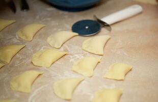 oud vrouw is voorbereidingen treffen eigengemaakt ravioli met kaas foto