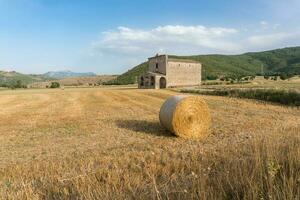 navelli, italië-augustus 9, 2021-weergave van de kerk van de Madonna del campo in de Open platteland gedurende een zonnig dag foto