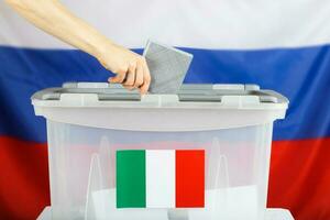 Italiaans inwoner inwoner in Rusland afgietsels haar stemming papier in een stemming doos. foto