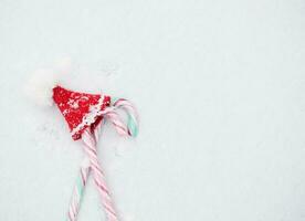 Kerstmis snoepjes en mini de kerstman claus hoed. vlak leggen foto