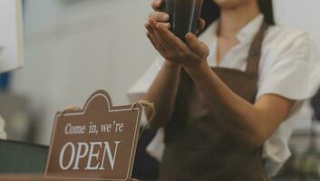 jong ondernemer Holding Open teken Aan glas deur Bij cafe foto