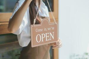 jong ondernemer Holding Open teken Aan glas deur Bij cafe foto