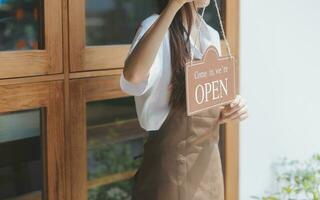 jong ondernemer Holding Open teken Aan glas deur Bij cafe foto