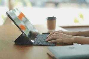 Aziatisch bedrijf vrouw gebruik makend van rekenmachine en laptop voor aan het doen wiskunde financiën Aan een kantoor bureau, belasting, rapport, boekhouding, statistieken, en analytisch Onderzoek concept foto