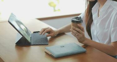 Aziatisch bedrijf vrouw gebruik makend van rekenmachine en laptop voor aan het doen wiskunde financiën Aan een kantoor bureau, belasting, rapport, boekhouding, statistieken, en analytisch Onderzoek concept foto