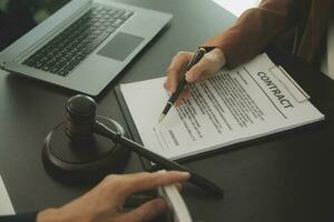 zaken en advocaten bespreken contractpapieren met koperen schaal op bureau in kantoor. wet, juridische diensten, advies, rechtvaardigheid en wet concept foto met film grain effect