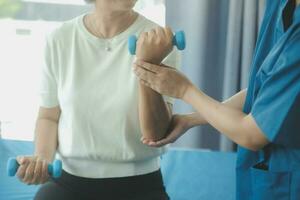 fysiotherapeut Mens geven oefening met halter behandeling over arm en schouder van atleet mannetje geduldig fysiek behandeling concept foto