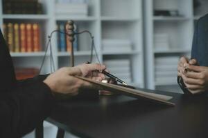 rechtvaardigheid en recht concept.male rechter in een rechtszaal met de hamer, werken met, computer en docking toetsenbord, brillen, op tafel in ochtendlicht foto