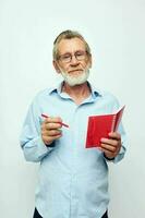 foto van gepensioneerd oud Mens rood kladblok schrijven licht achtergrond