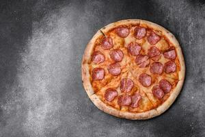 smakelijk vers pizza met salami, kaas, tomaten, specerijen en zout foto