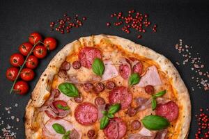 heerlijk vers oven gebakken pizza met salami, vlees, kaas, tomaten foto