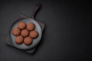 heerlijk zoet chocola koekjes Aan een zwart keramisch bord foto