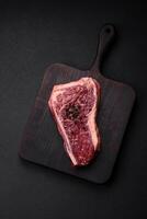 vers sappig rauw nieuw york rundvlees steak met zout, specerijen en kruiden foto