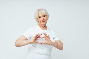 foto van gepensioneerd oud dame in een wit t-shirt licht achtergrond