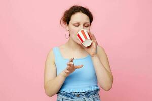 vrolijk emotioneel vrouw met beschikbaar glas van drinken roze achtergrond foto