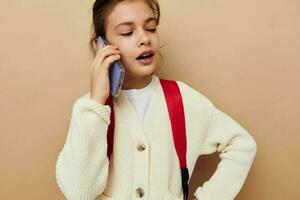 schattig meisje schoolmeisje rugzak telefoon in hand- geïsoleerd achtergrond foto