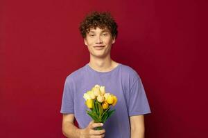 schattig tiener Holding een geel boeket van bloemen Purper t-shirts rood achtergrond ongewijzigd foto