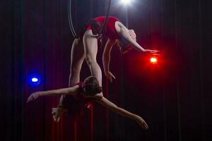 circus acrobaten gymnasten uitvoeren Aan een stadium donker achtergrond. foto